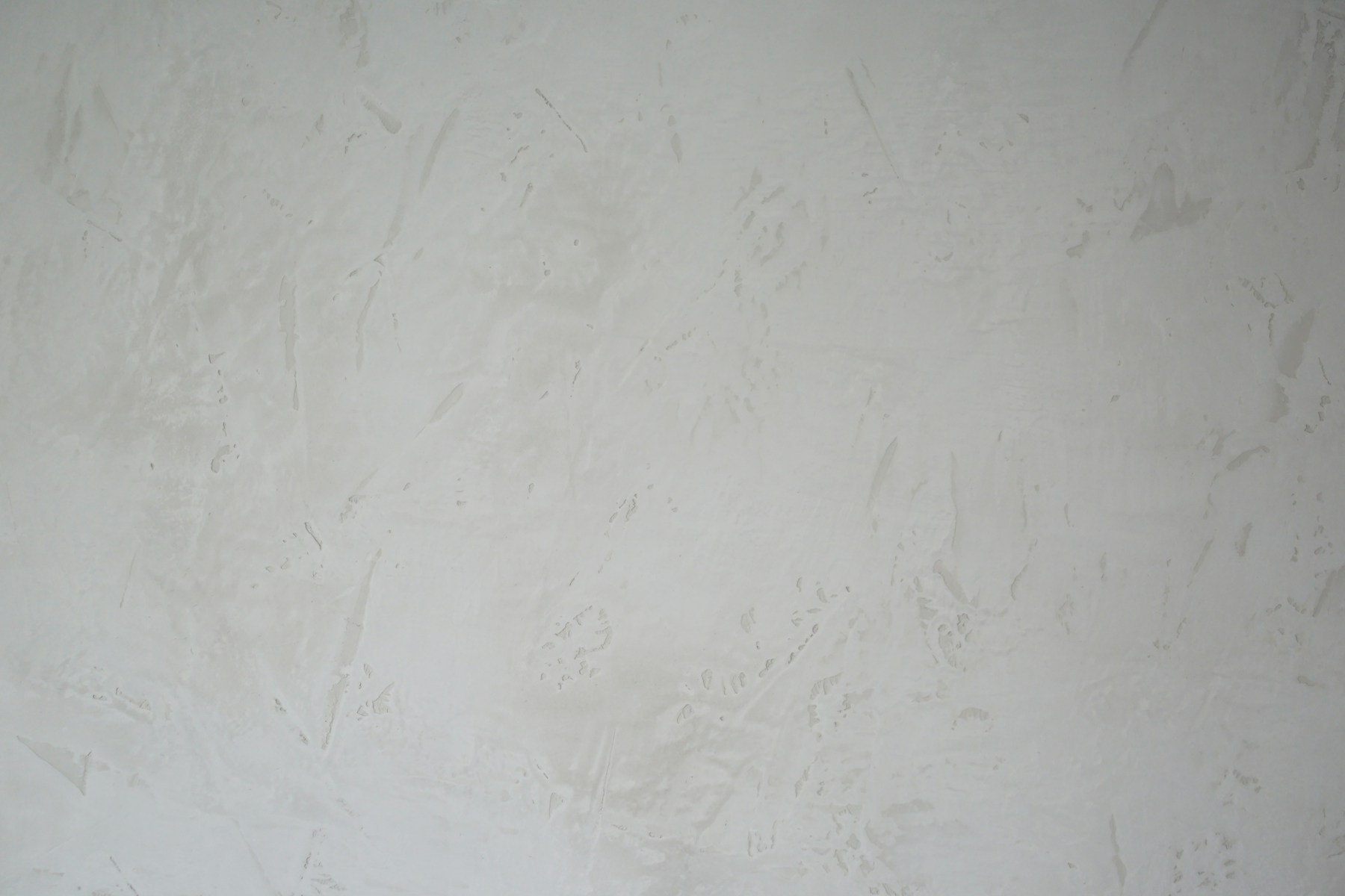 Application d'un enduit décoratif à la taloche sur un mur
